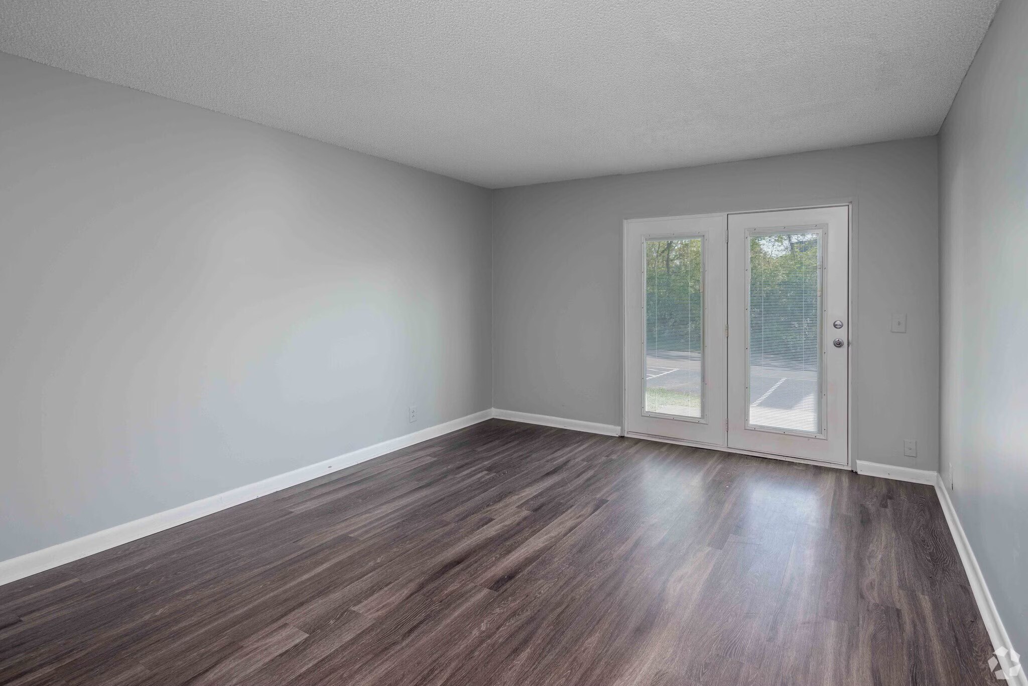 A room with a wooden floor and a sliding glass door.